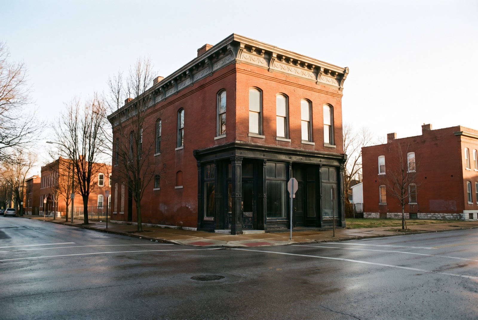 A two-story brick corner storefront with a bracketed metal cornice