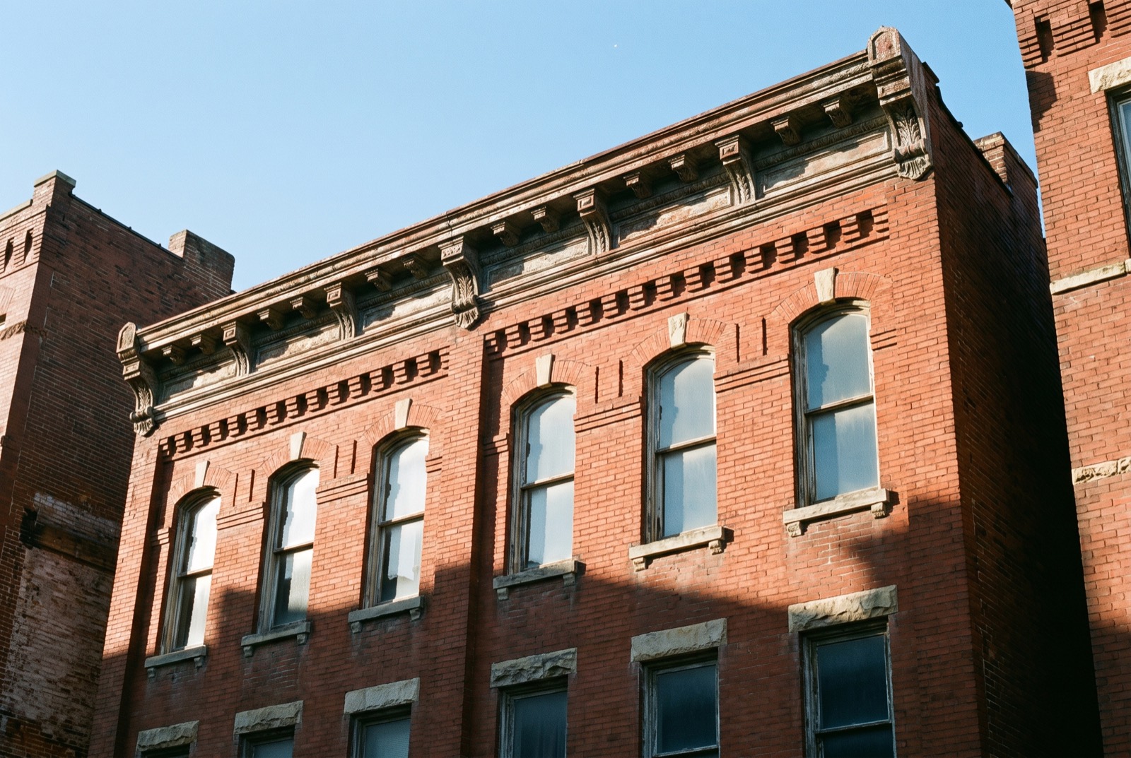 The corbelled brick and pressed-metal cornice of an old St. Louis commercial building, seen from the street
