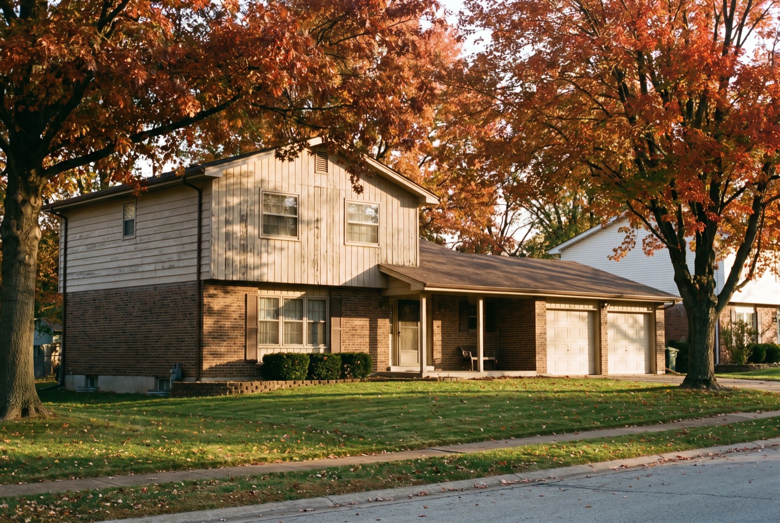 A 1970 split-level house with mature trees in a St. Louis suburb