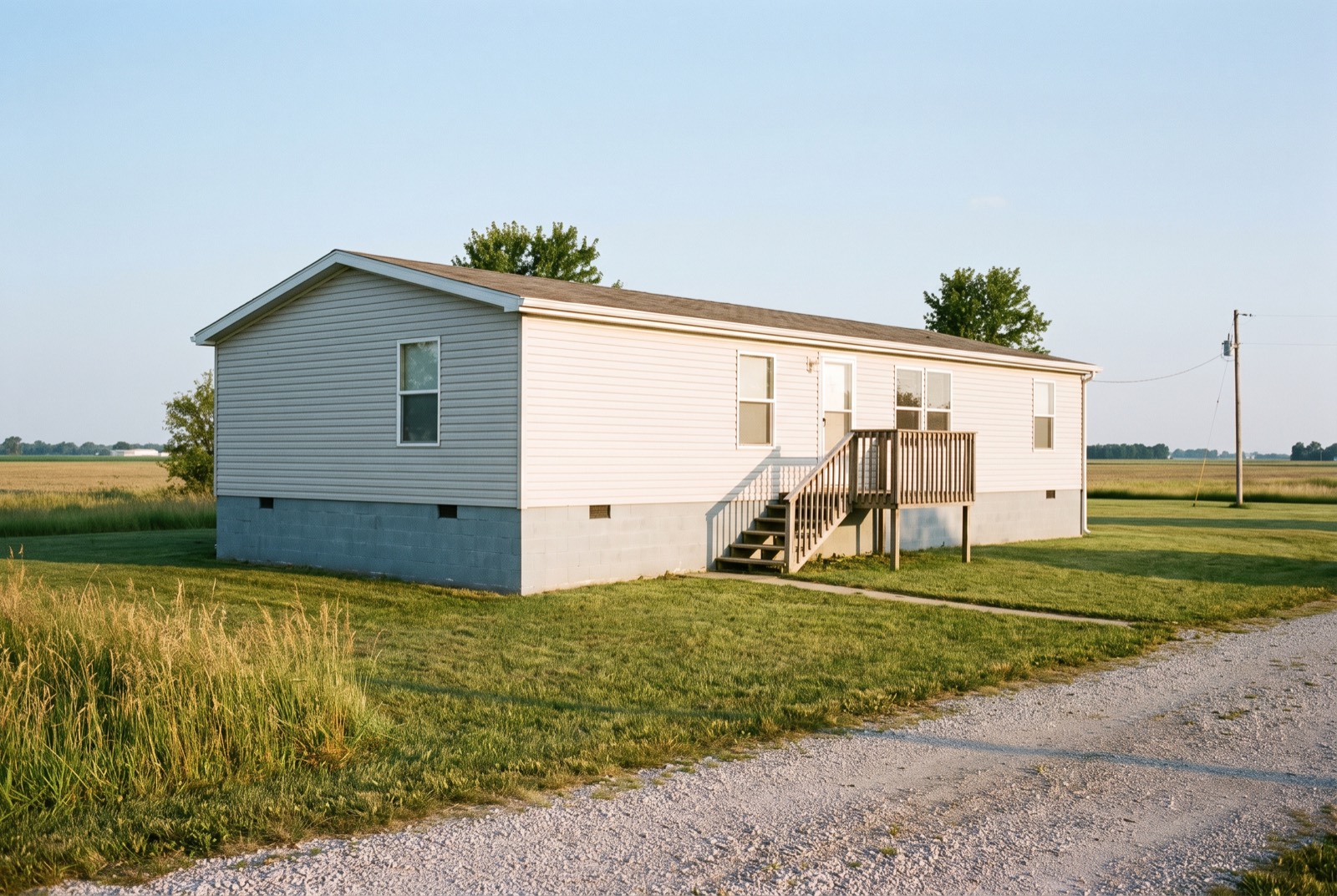 A manufactured home on a permanent masonry foundation with steps and a landing at the front door